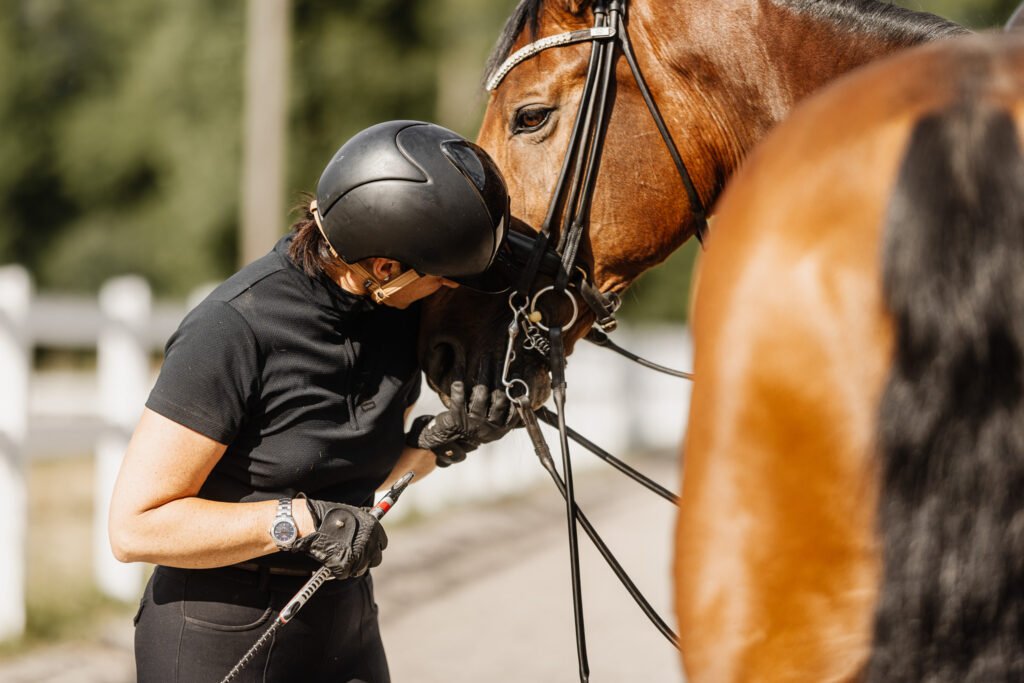 Eine Frau streichelt den Kopf eines Pferdes.