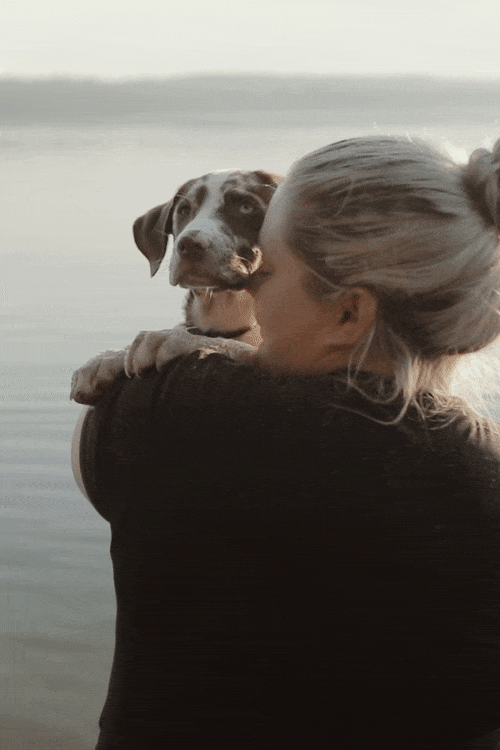 Frau mit Hund am Wasser